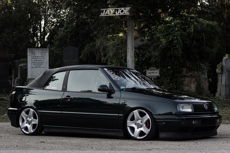 a black car parked in front of a cemetery