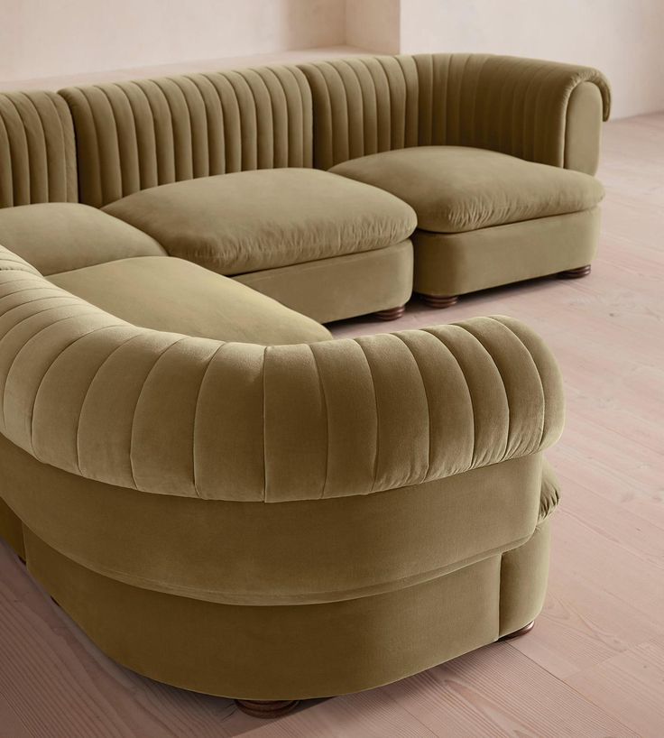 a curved couch sitting on top of a hard wood floor