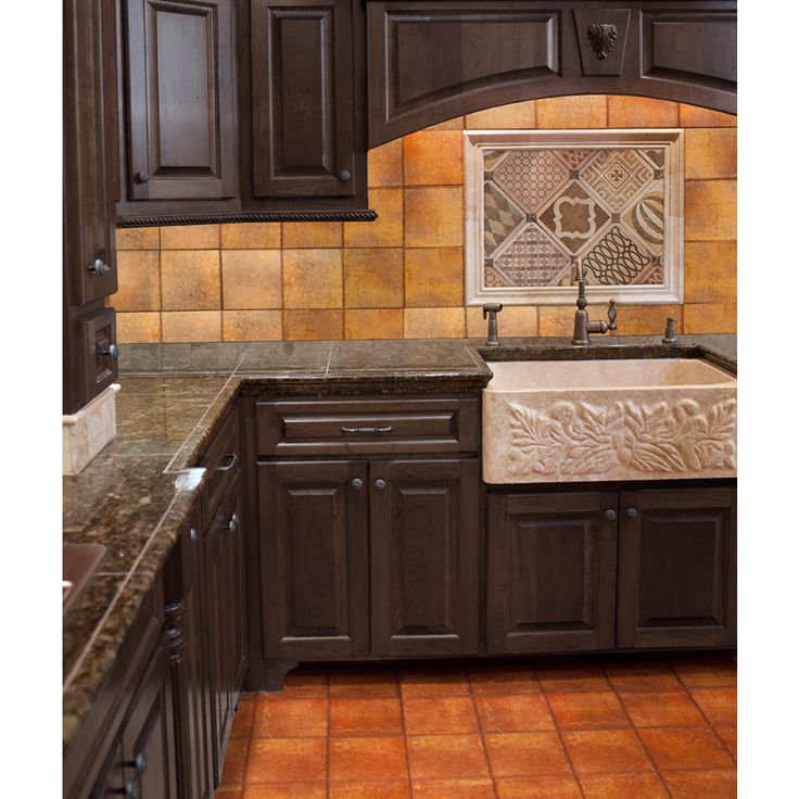 a kitchen with brown cabinets and marble counter tops