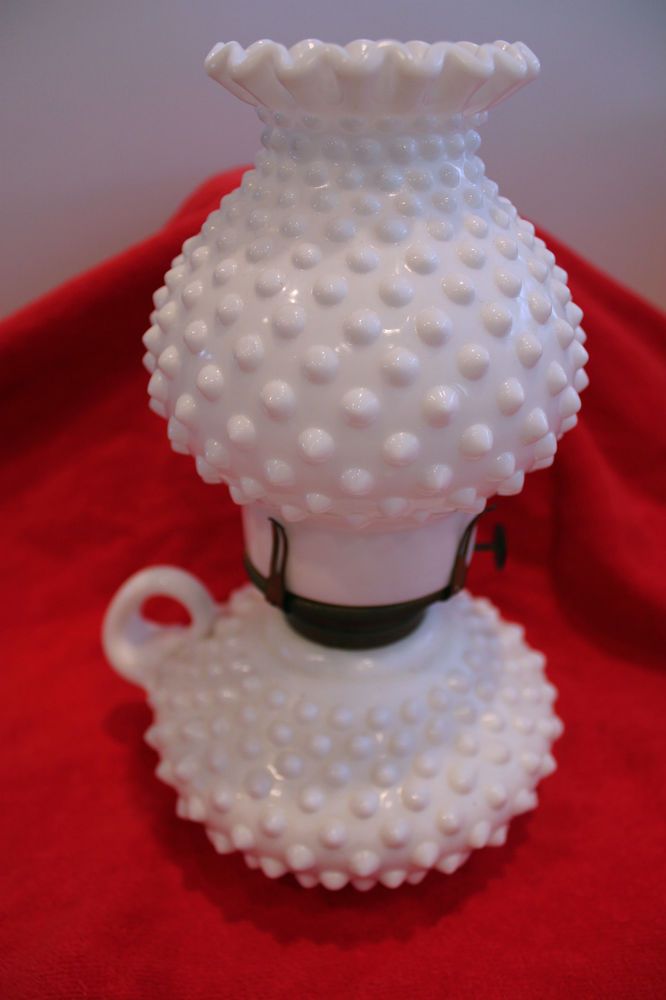 a white vase sitting on top of a red cloth