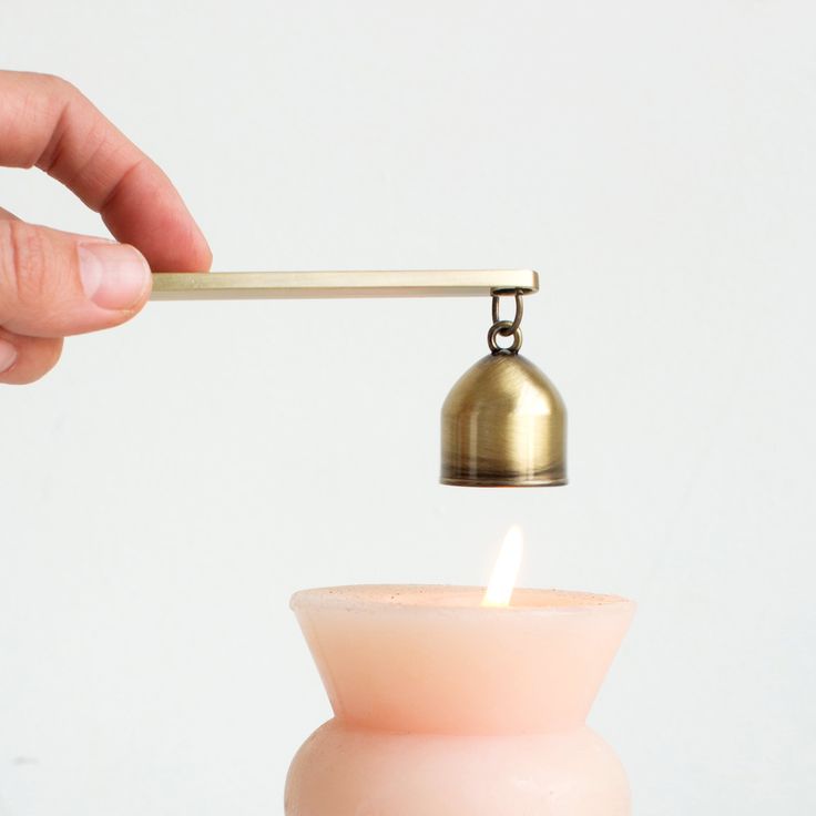 a person holding a small candle with a light on it and a lighter in the other hand