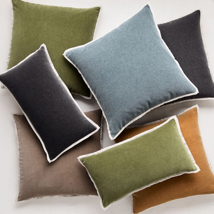 four different colored pillows sitting on top of each other