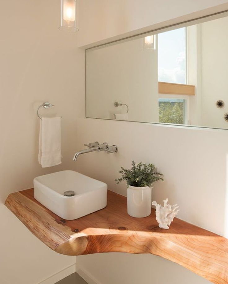 a bathroom with a wooden counter and mirror