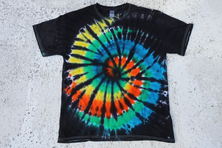 a tie - dyed t - shirt is laying on the ground with it's colorful colors