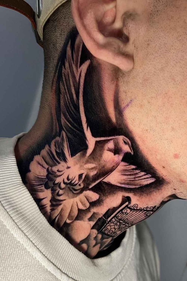 a man's neck with a bird and flowers tattoo on the back of his neck