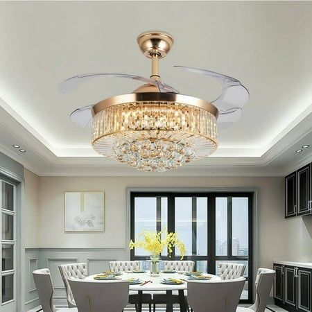 a chandelier hanging from the ceiling above a dining room table with white chairs