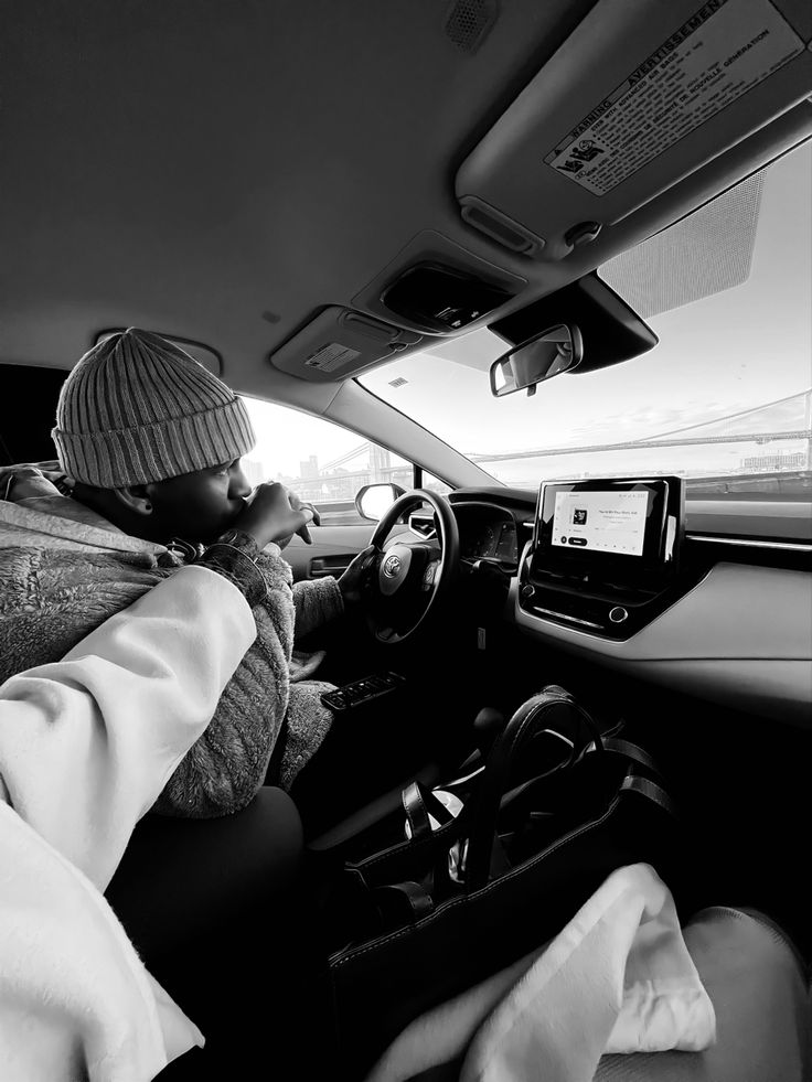 black and white photograph of a man driving a car