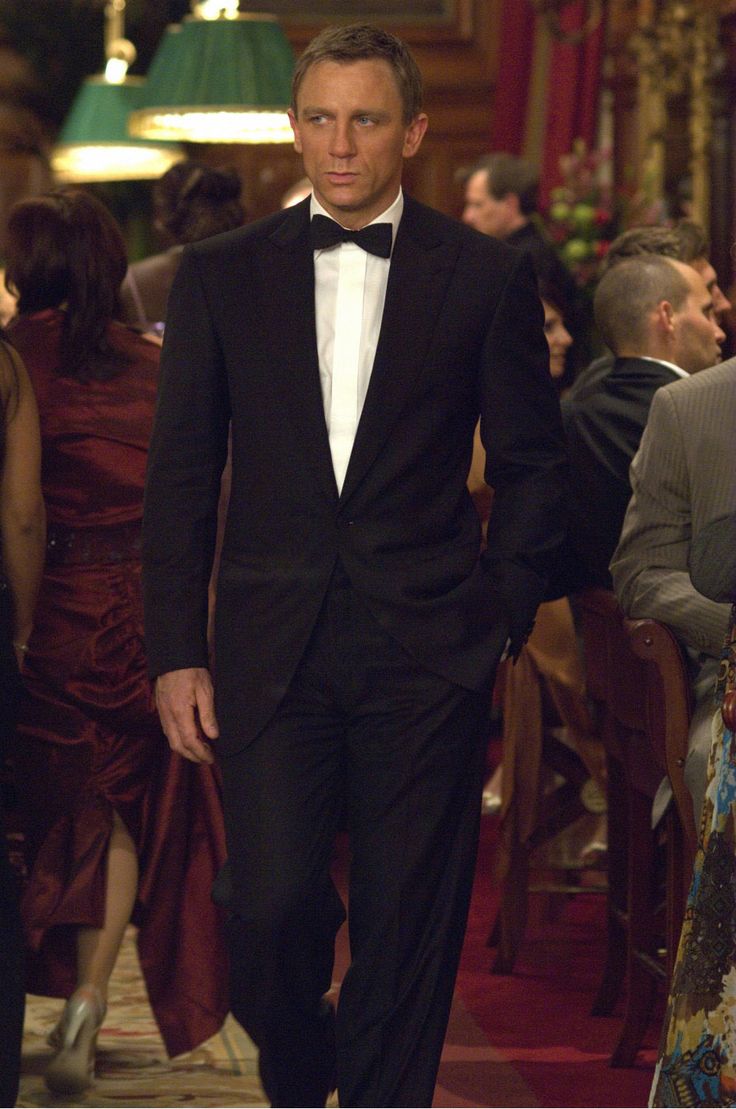 a man in a tuxedo walking down a hall