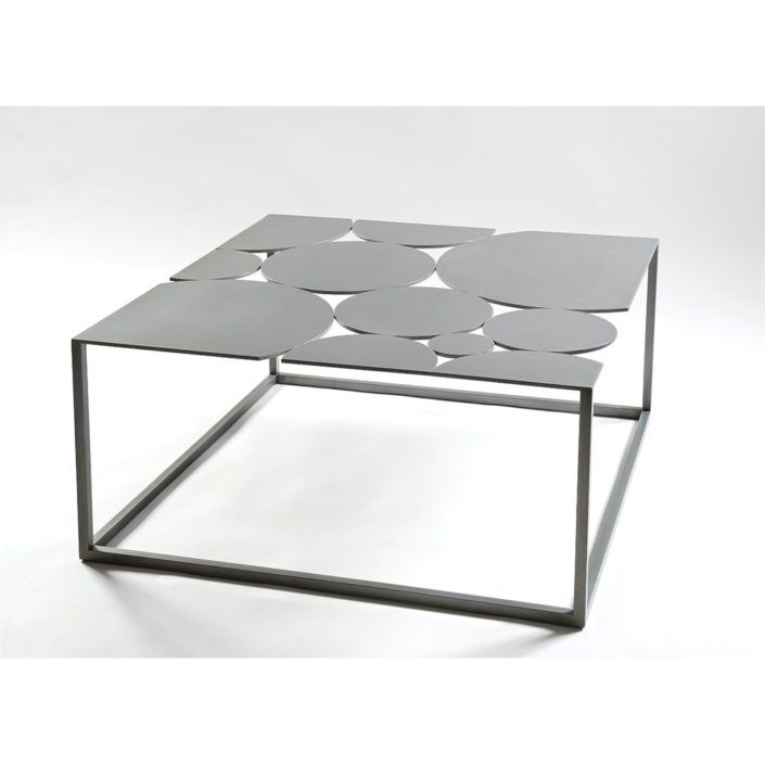 a modern coffee table with circles on the top and metal frame, against a white background