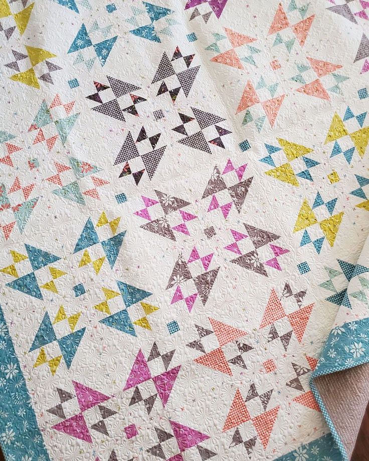 a colorful quilt on top of a wooden table