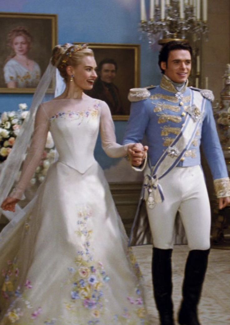 a man and woman dressed in wedding attire holding hands while standing next to each other