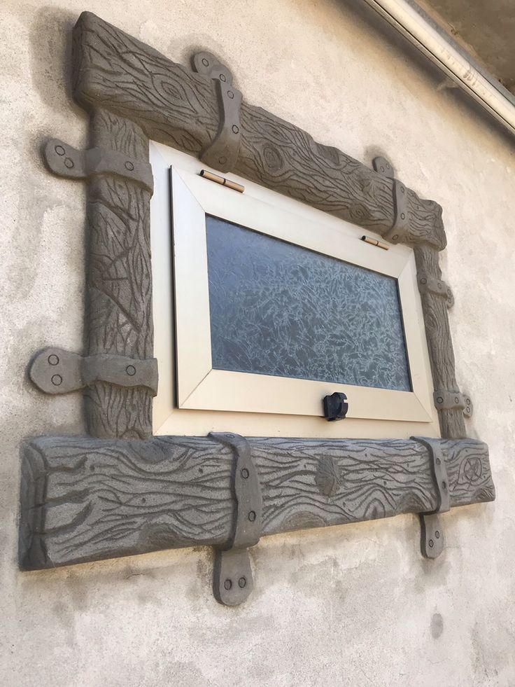 a window on the side of a building that is made out of wood and metal