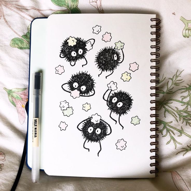 an open notebook with black and white drawings on it