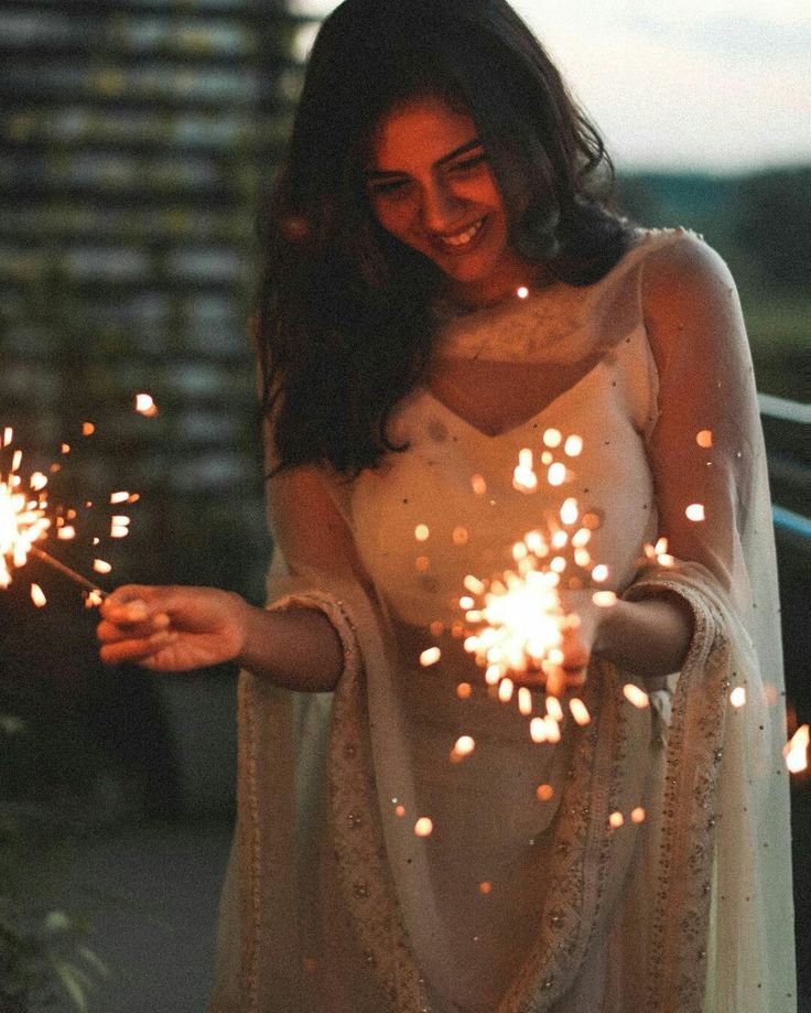 a woman holding sparklers in her hands