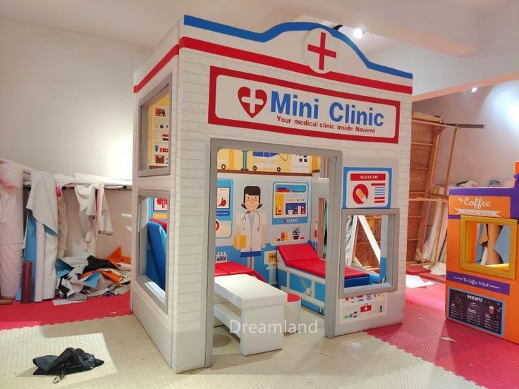 a small child's hospital room with toys and medical supplies on the floor in front of it