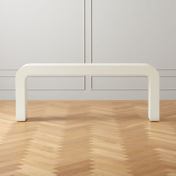 a white bench sitting on top of a hard wood floor