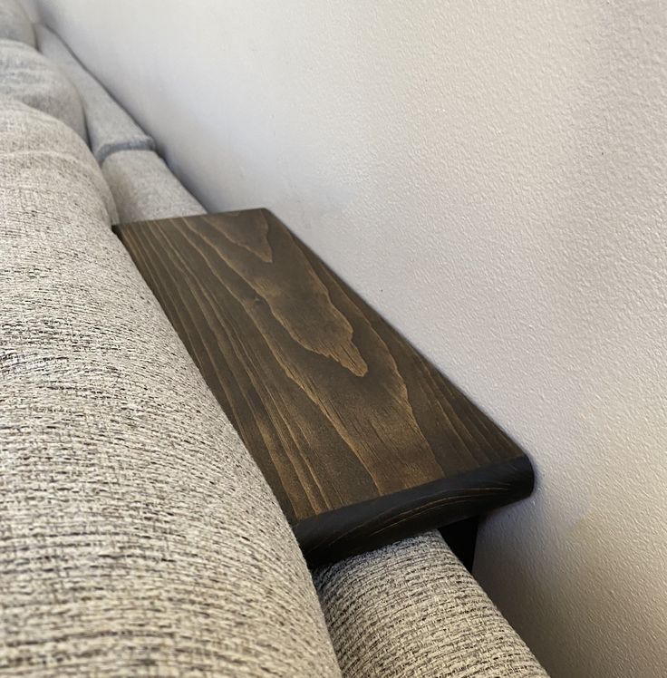 a wooden bench sitting on top of a gray couch