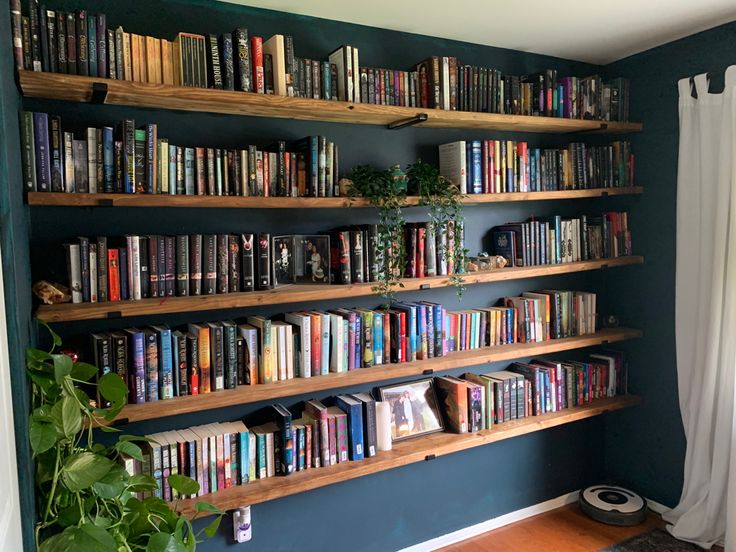 a bookshelf filled with lots of books next to a window