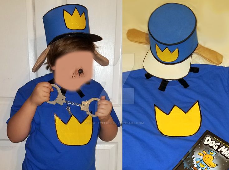 a child wearing a blue shirt and hat holding a pair of scissors in front of his face