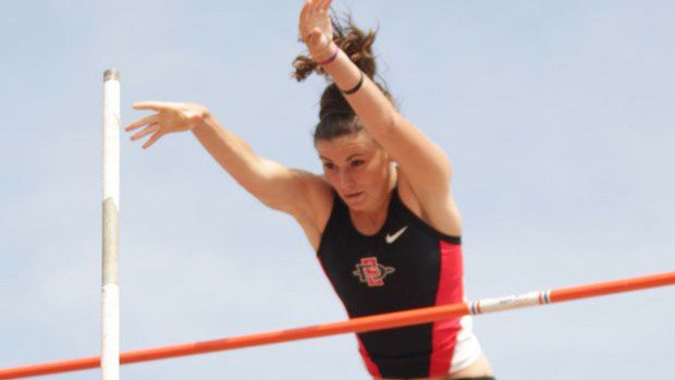 a woman jumping over an orange pole on a high jump