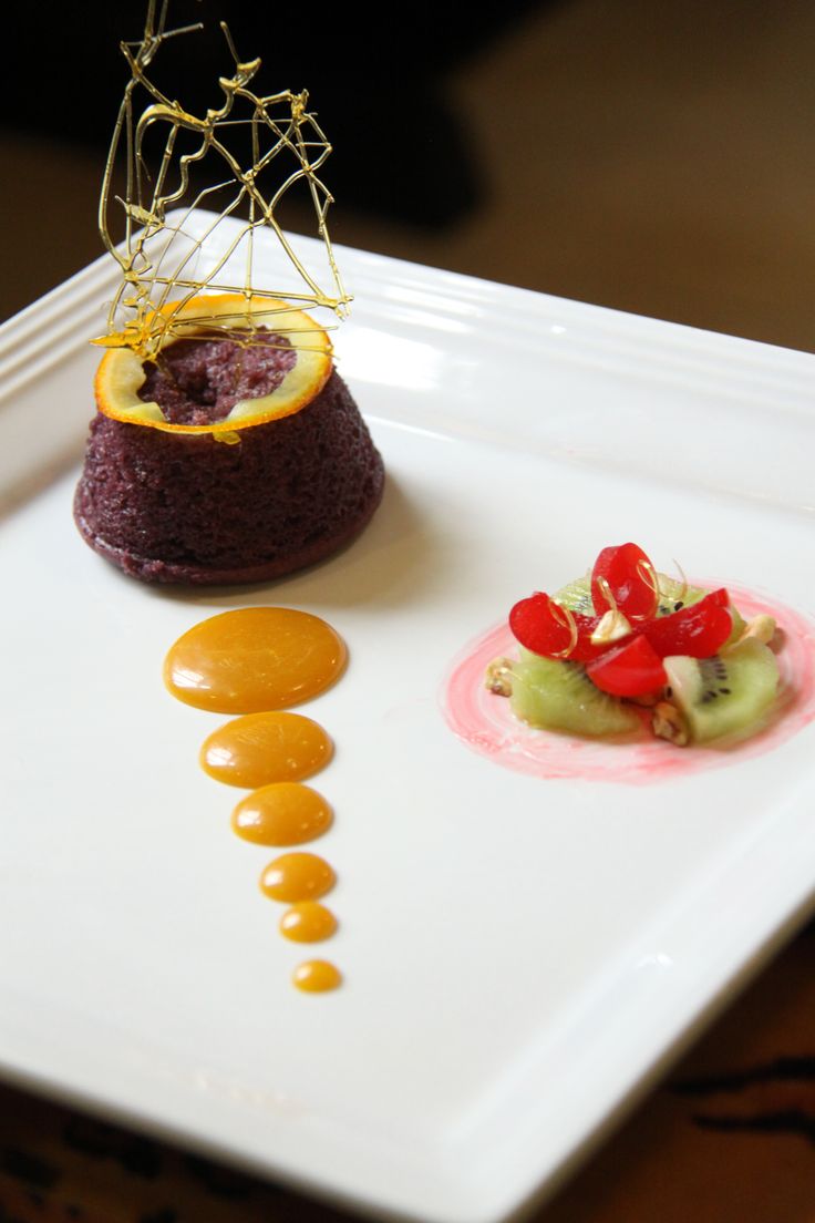 a white plate topped with a dessert covered in fruit