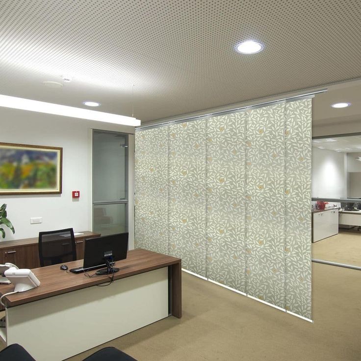 an office cubicle with sliding glass doors and a desk in front of the door