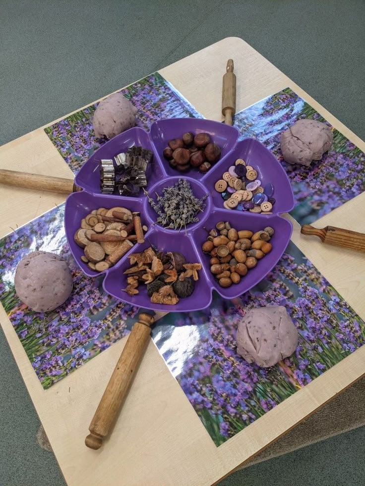 a purple plate filled with different types of food on top of a wooden table next to baseball bats