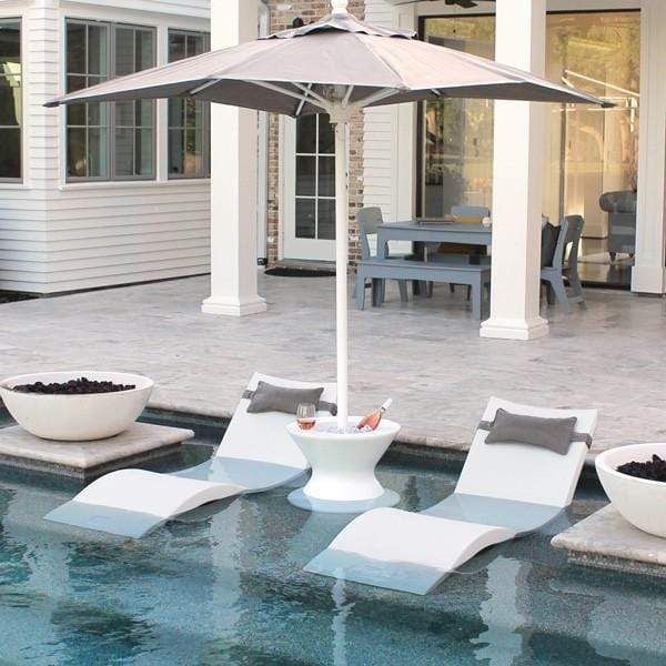 an outdoor pool with lounge chairs and an umbrella