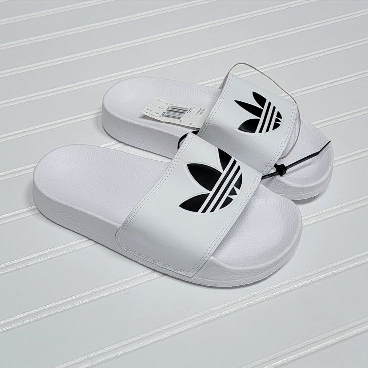 Nwt Adidas Adilette Lite Slides/Sandals, Size 3 Big Kid, White With Black Logo, White Beach Slippers With Cushioned Footbed, White Cushioned Beach Slippers, Trendy White Sport Sandals With Round Toe, White Round Toe Sport Sandals For Summer, Trendy White Round Toe Sport Sandals, Comfortable White Slip-on Sandals, White Synthetic Slip-on Slippers, White Closed Toe Sport Sandals For Summer, Trendy White Round Toe Sandals