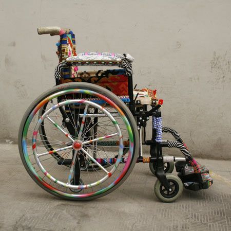 a wheel chair that has been decorated with many different colors and designs on the wheels