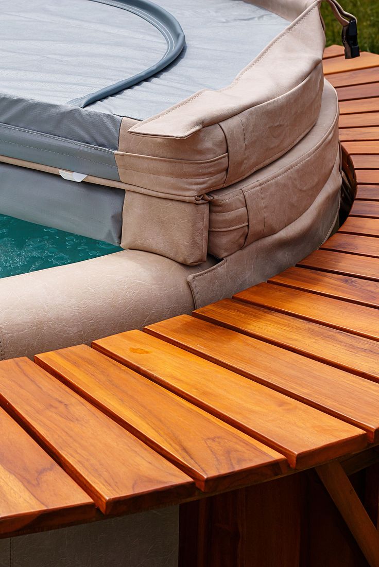 an inflatable swimming pool with a wooden table and bench next to the pool