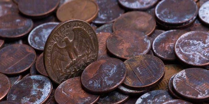 a pile of old pennets with one penny on the top and another penny in the middle