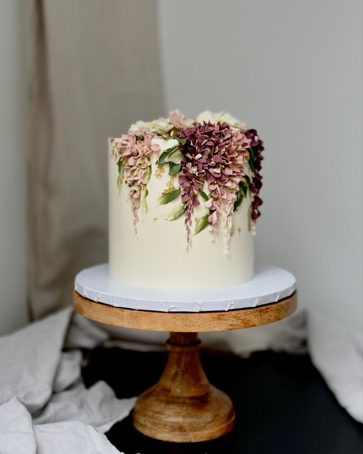 a white cake with purple flowers on top