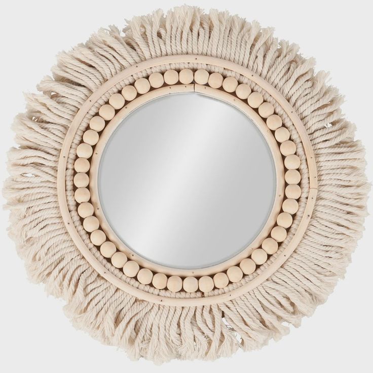 a round mirror with tassels around it