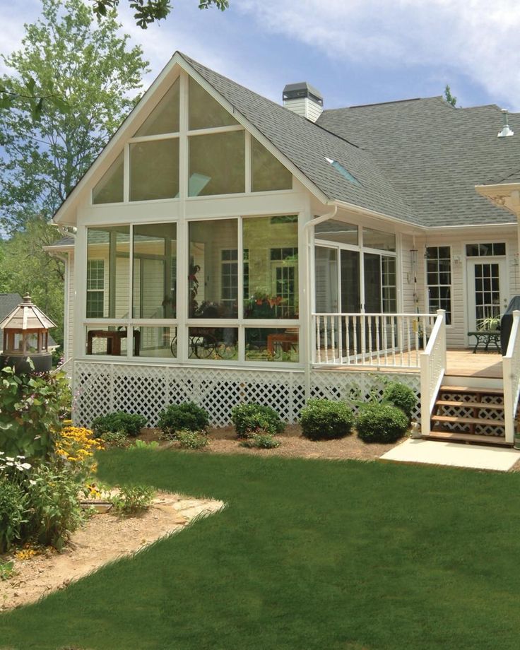 a large white house sitting on top of a lush green field