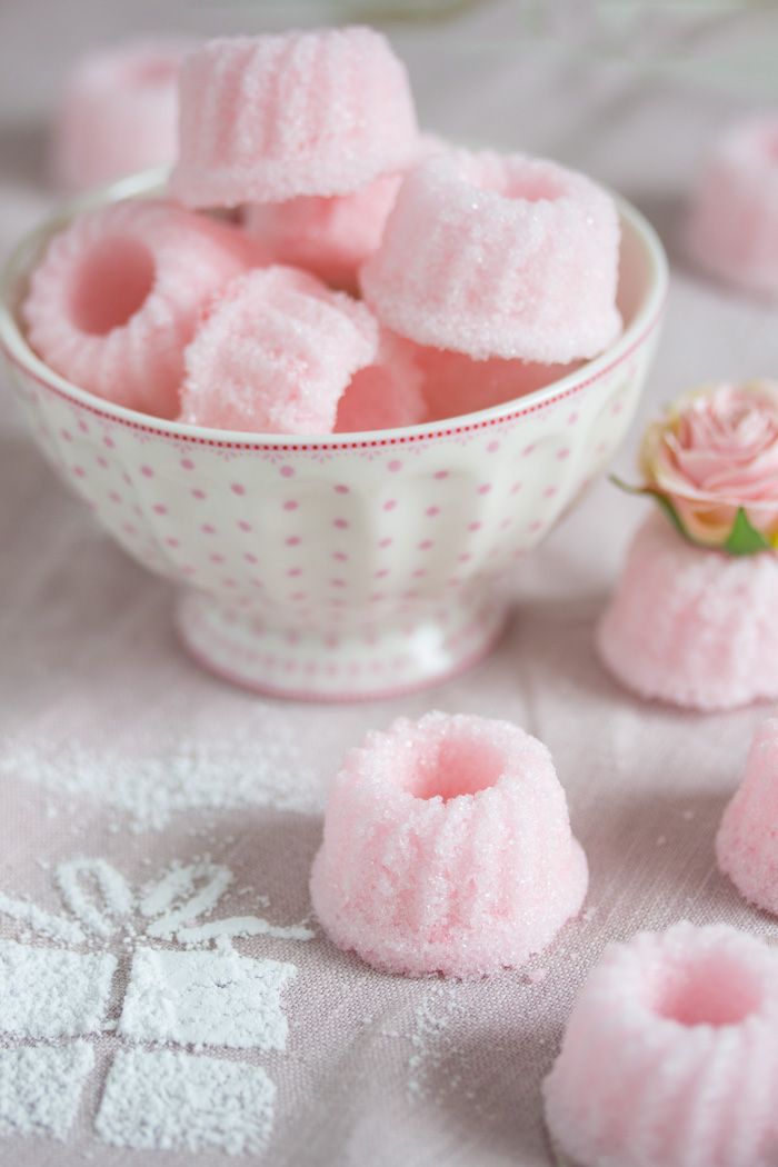 a bowl filled with pink marshmallows on top of a white table cloth