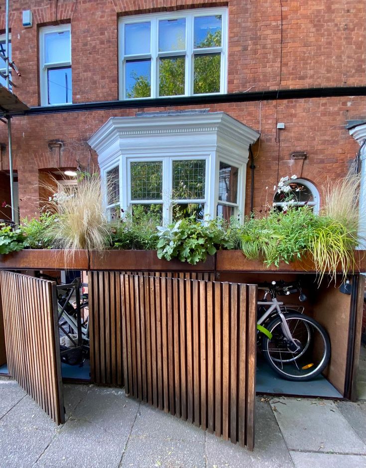 a bike is parked next to a wooden planter