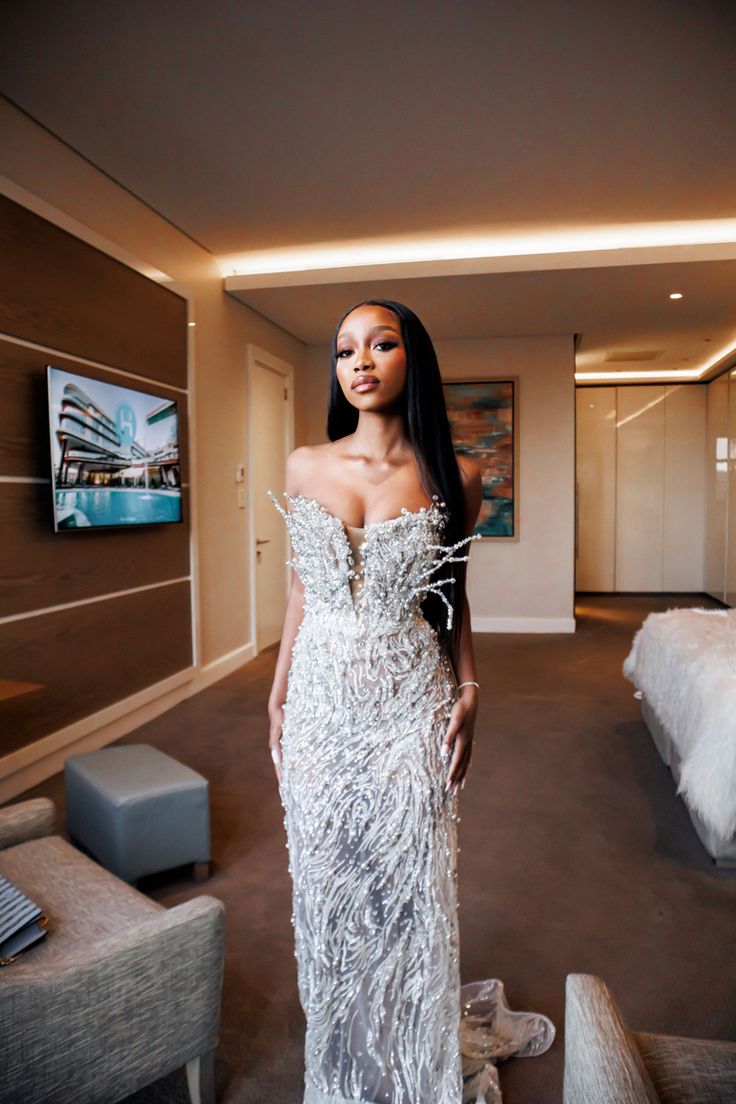 a woman in a white dress standing in a room