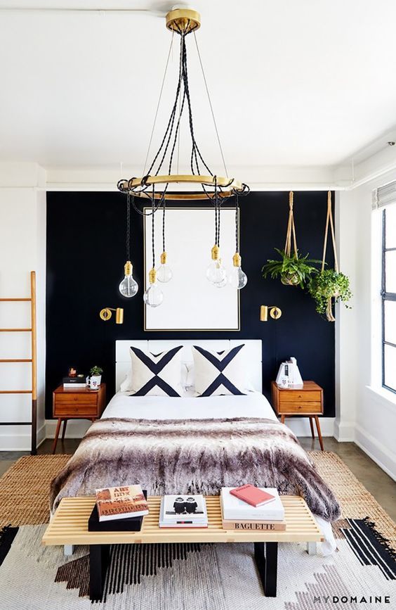 the bedroom is decorated in navy blue and white with gold accents, including a chandelier