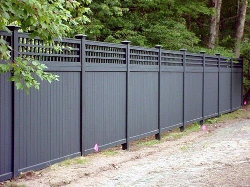 a black fence in front of some trees