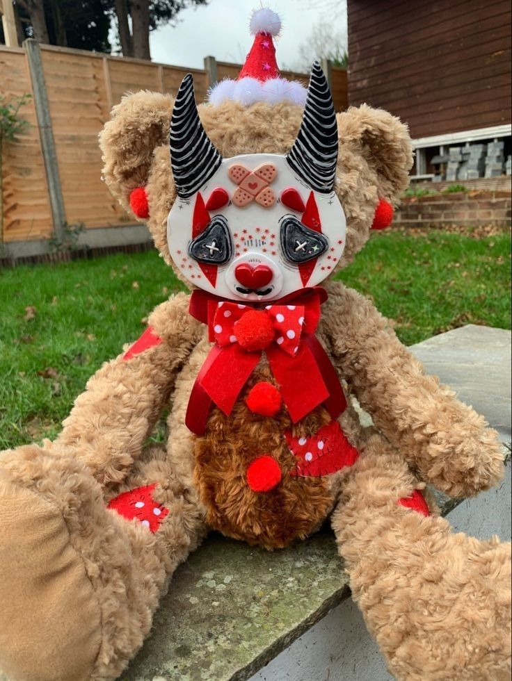 a teddy bear wearing a mask and sitting on a stone ledge in front of a house