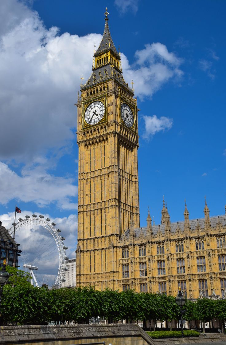 the big ben clock tower towering over the city of london, england with ferris wheel in the background