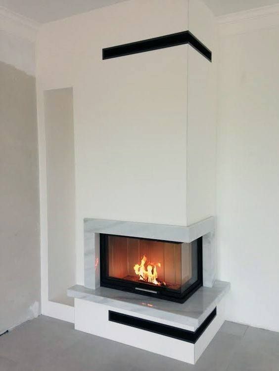 a fire place in the middle of a room with white walls and flooring on both sides