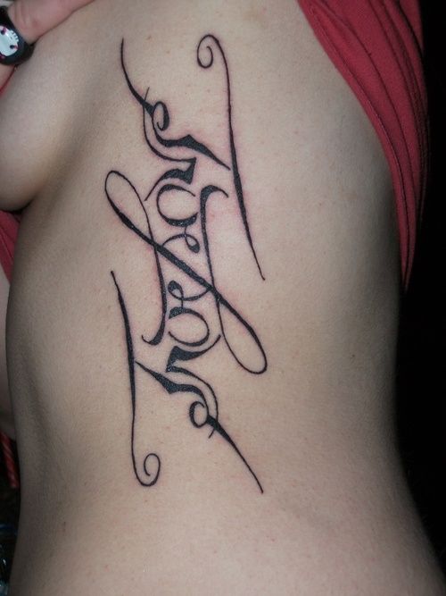 a woman's lower back tattoo with the word love written in cursive writing