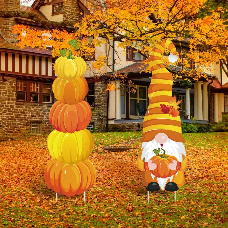 two pumpkins are stacked on top of each other in front of a large house