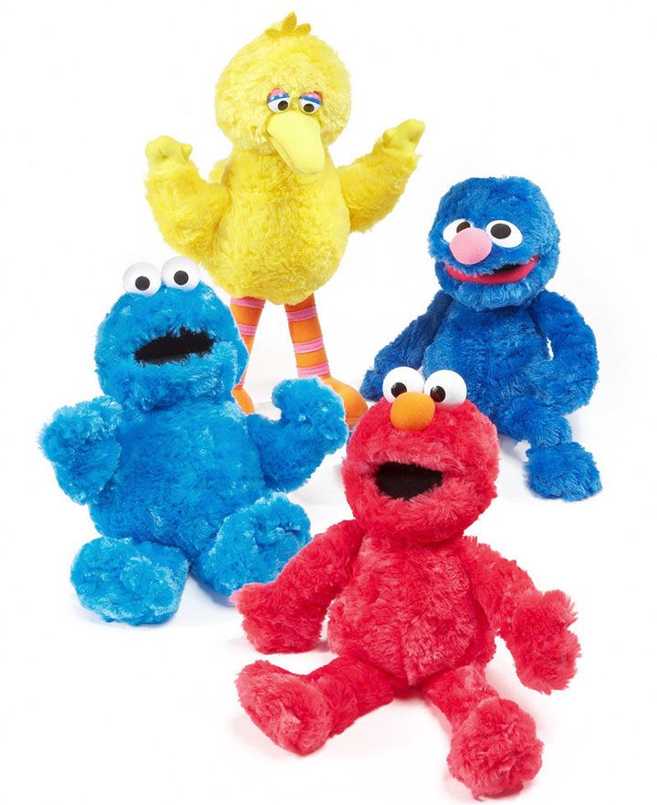 three sesame street characters are posed together in front of the camera, one is blue and one is red