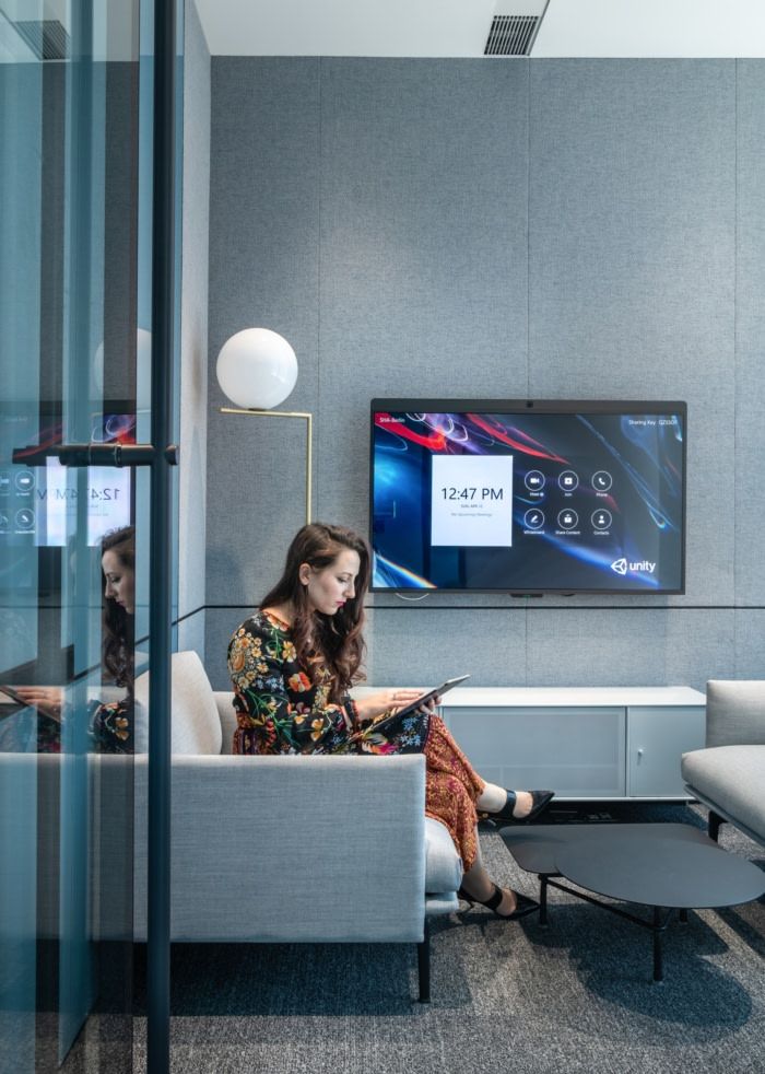 a woman sitting on a couch in front of a flat screen tv