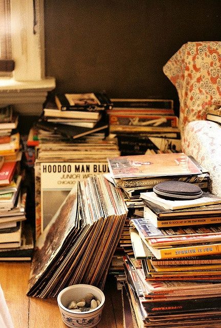 a pile of records sitting on top of a wooden floor