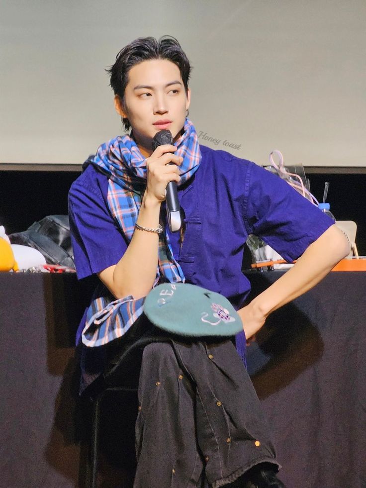 a man holding a microphone while sitting down