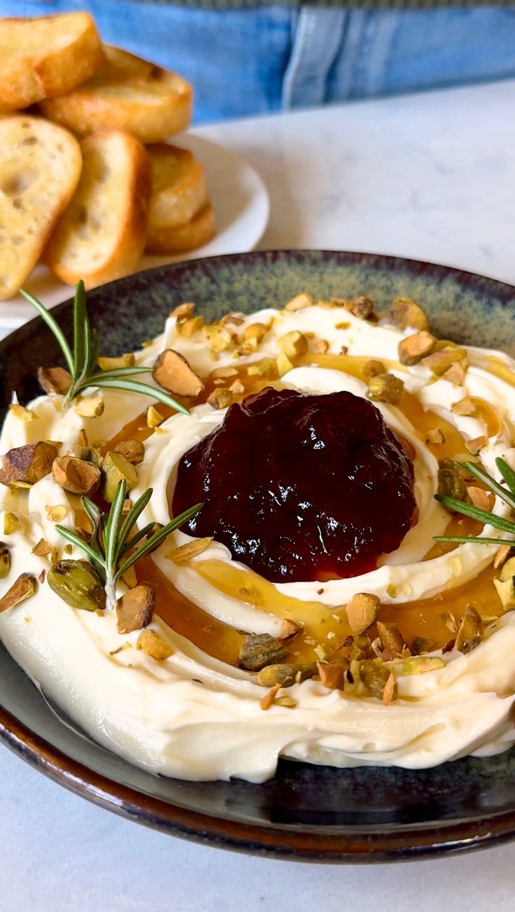 a plate topped with whipped cream and toppings next to toasted bread on a table